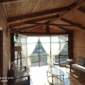 Perdeleri takılı üst kat salon 2 berceri olan boydan camlı 220 m2 ağaç ev iç salon görseli