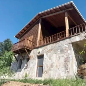 Gökyüzünün mavisi yeşil manzara içinde verandada oturup bişeyler içmek için tasarlanmış yapı