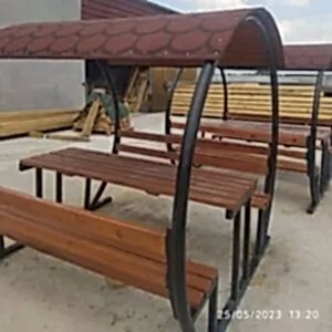 Kenarları yuvarlak üzeri kırmızı şıngıl olan çatılı piknik masası, kamelya