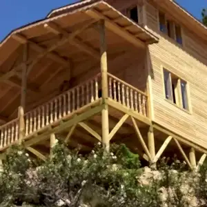 Yerden çekilmiş iki katlı önü verandalı ve yuvarlak ayaklı ahşap ev