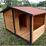 Dost ahşap köpek kulübesi, siyah çerçeveli ve kırmızı çatılı, çim üzerinde.